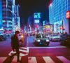 Straße in Japan bei Nacht, Mann geht über Zebrastreifen